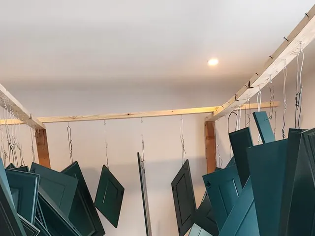Cabinet doors prepared and painted in a deep green finish.