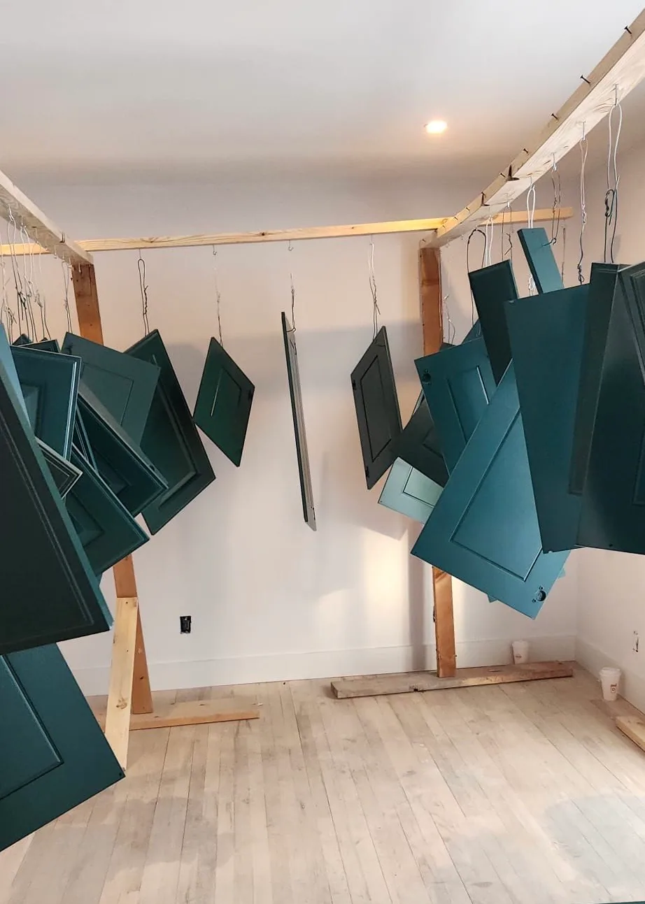 Cabinet doors prepared and painted in a deep green finish.